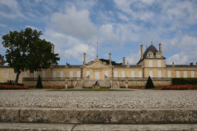 芝生と樹木の向こうに横長の白い館が立つシャトー・ベイシュヴェルの全景